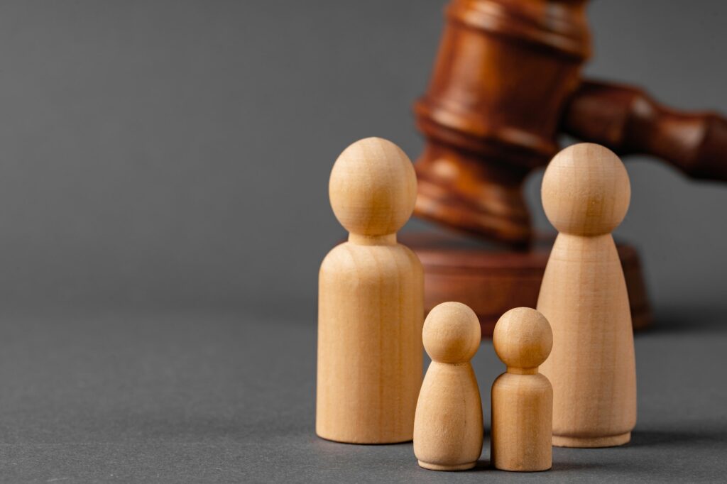 Wooden toy family and judge mallet. Family divorce concept